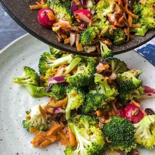 overhead of vegan broccoli salad being poured on a serving dish.