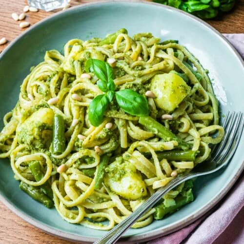 close-up overhead of trenette al pesto pasta in a dish with a fork.