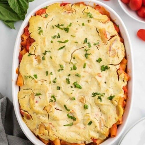 overhead of vegan baked ziti in a white casserole dish after baking.