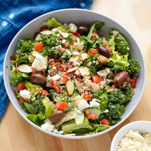 Panera Greek salad served in a large bowl. A blue kitchen towel place next to the bowl.