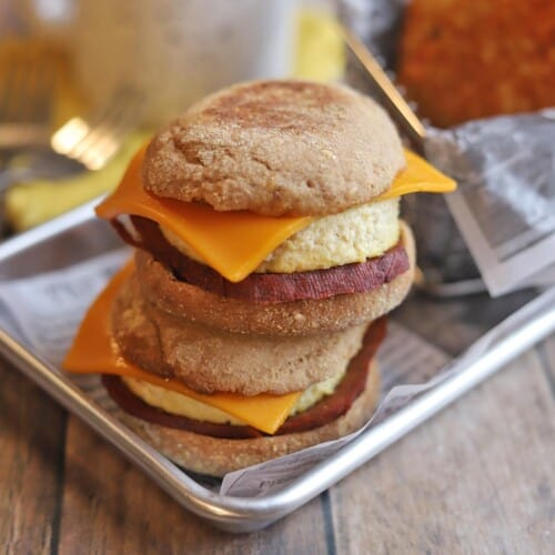 Two vegan egg mcmuffins stacked on each and placed on a baking sheet.