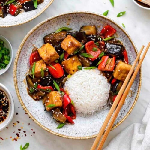 A blue bowl filled with Panda Express Eggplant Tofu Recipe topped with green onion and sesame seeds.