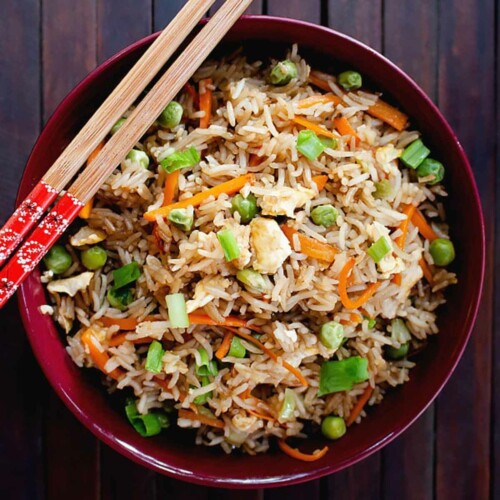 Panda Express Fried Rice served in a dark red bowl with chopstick placed on it.