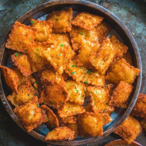 A round tray filled with Copycat Olive Garden Fried Ravioli.