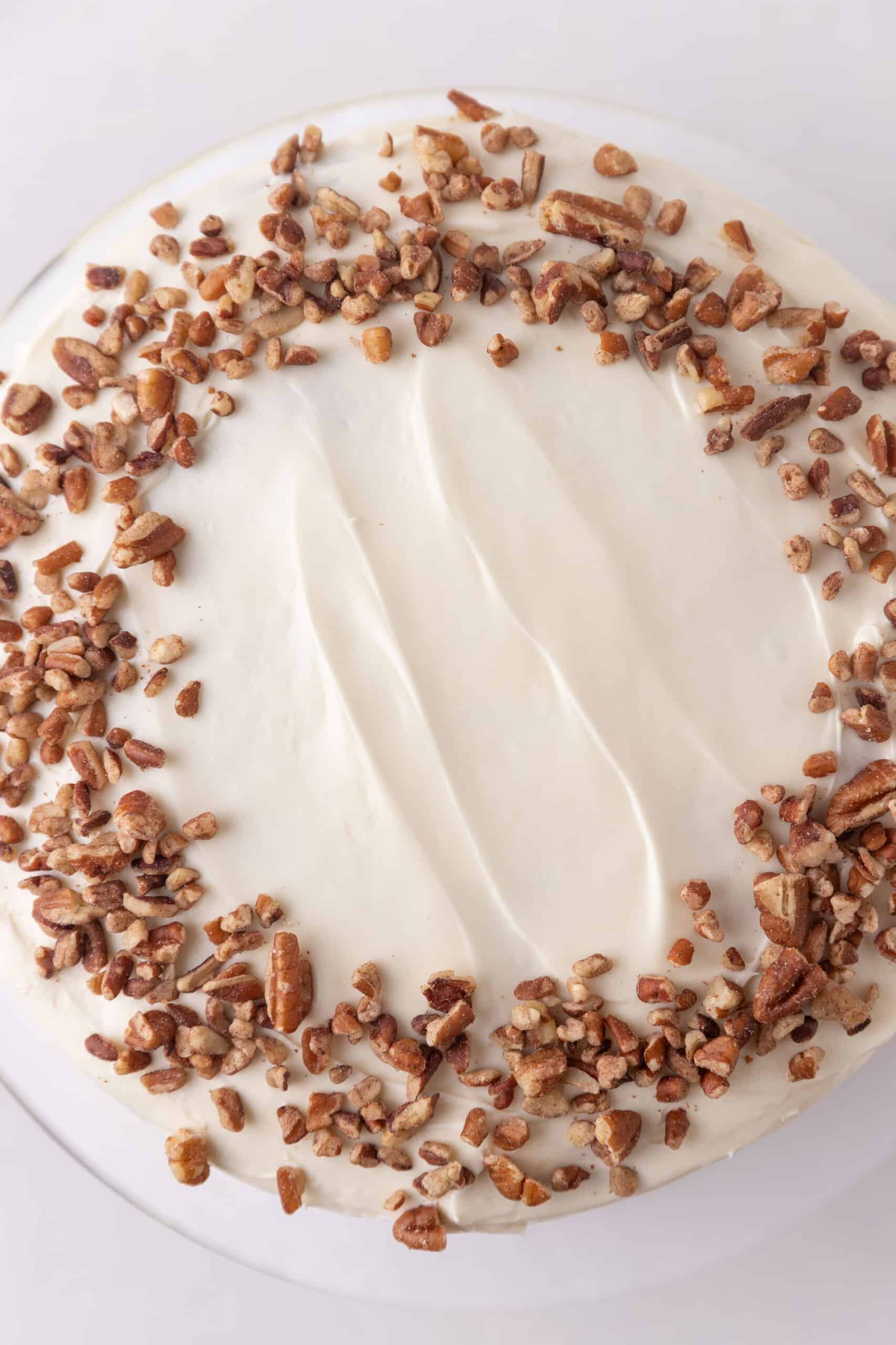 Frosted vegan carrot cake with pecans.