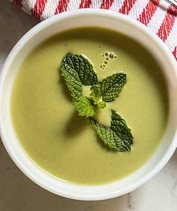 Cucumber Mint Soup served in a bowl garnished with mint leaf