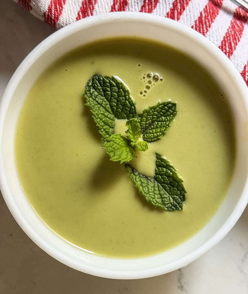 Cucumber Mint Soup served in a bowl garnished with mint leaf