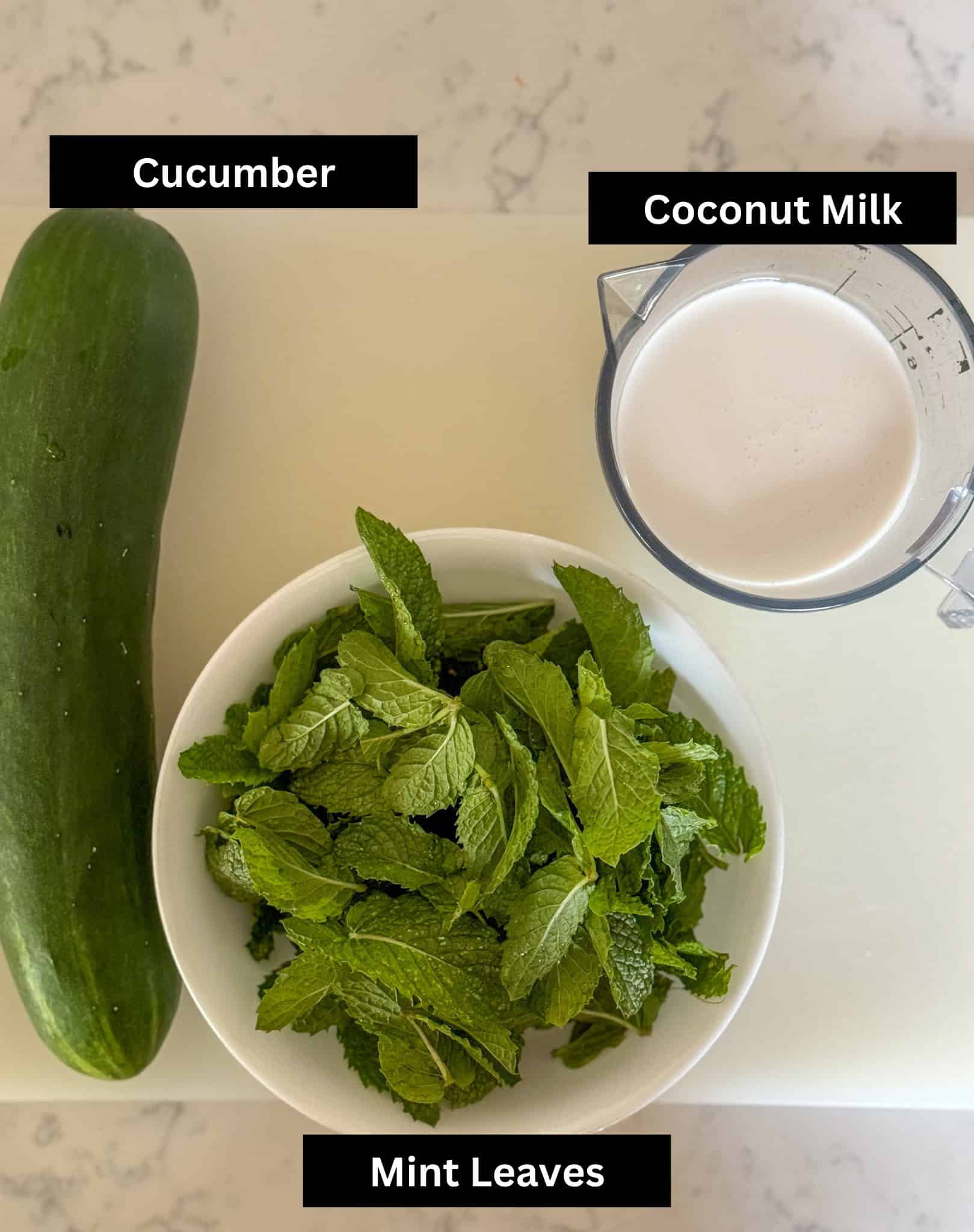 Ingredients for cucumber mint soup laid out on a cutting board