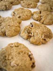 Baked Oatmeal Coconut Cookies on parchment paper with walnuts mixed