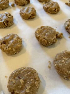 Flattened Oatmeal Dough Balls on parchment paper