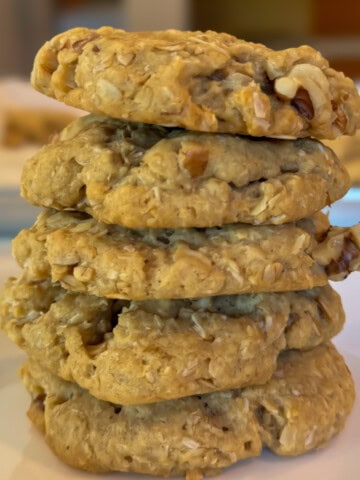 stack of oatmeal coconut walnut cookies on a white plate feature image 1200x1200