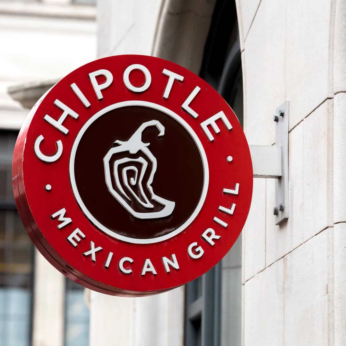 Chipotle Logo hanging on the concrete wall - feature image for vegan options at chipotle article