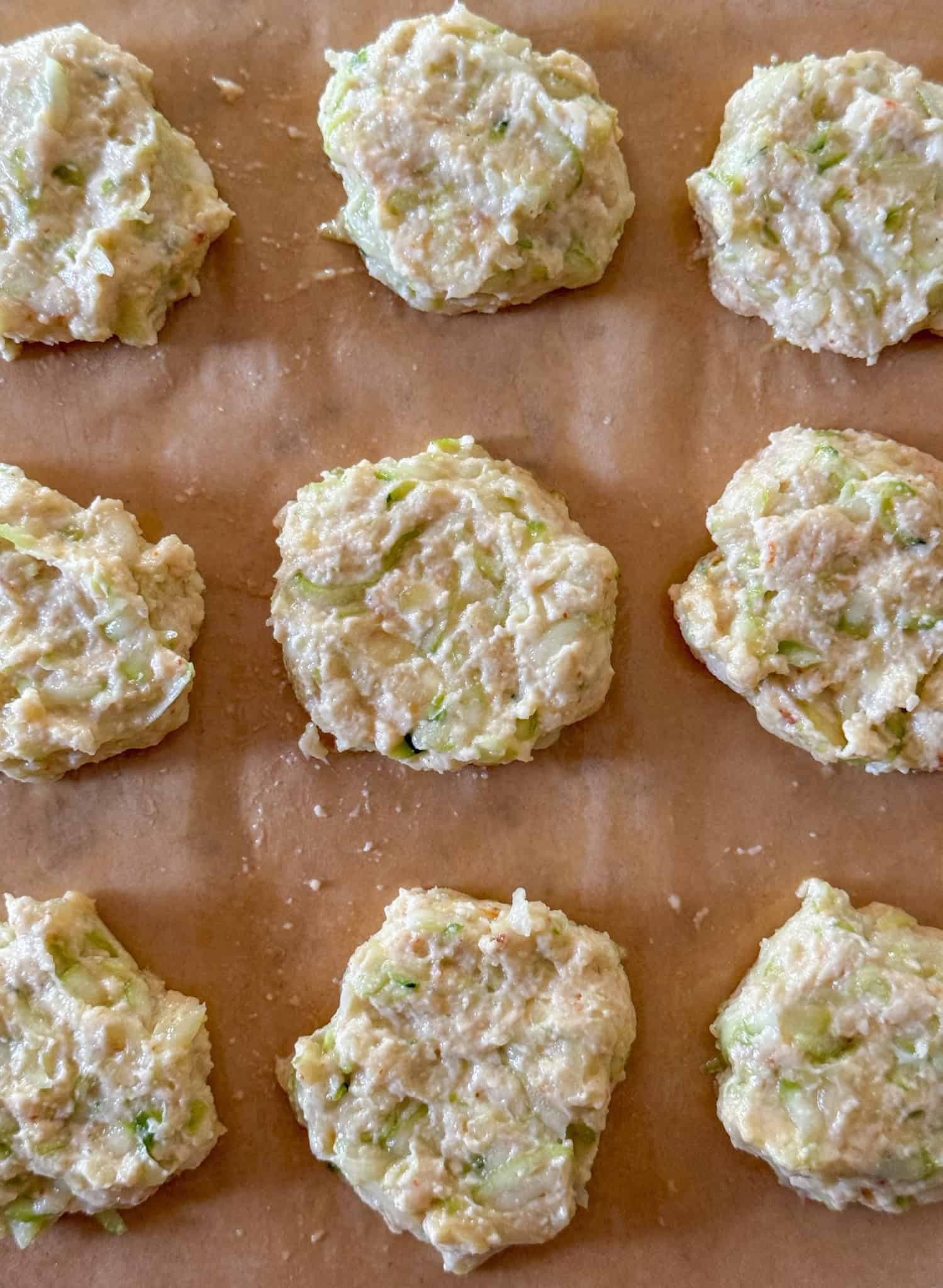 zucchini squash patty batter shaped on air fryer liner ready to go into the air fryer