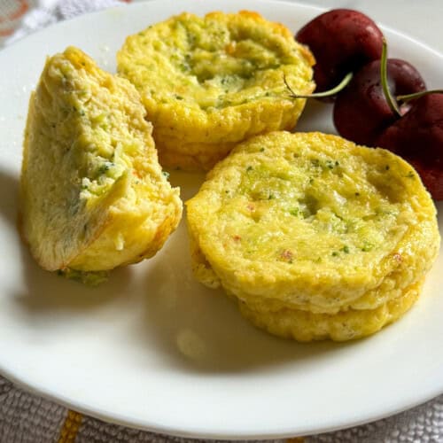 Plate of 3 cottage cheese egg bites served with 3 cherries - With yellow light