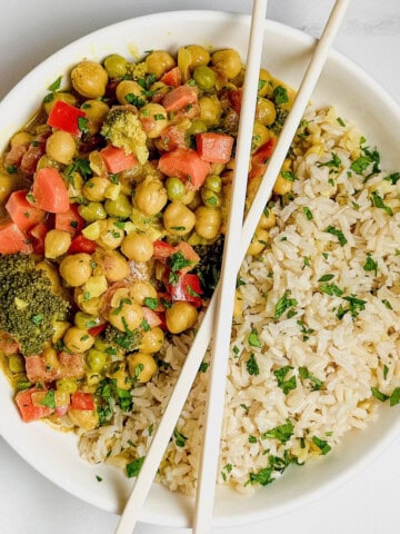 Vegan Curry served with Rice in a white bowl with chopsticks on top