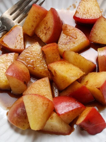 Cinnamon apples served on a plate with a fork on the side