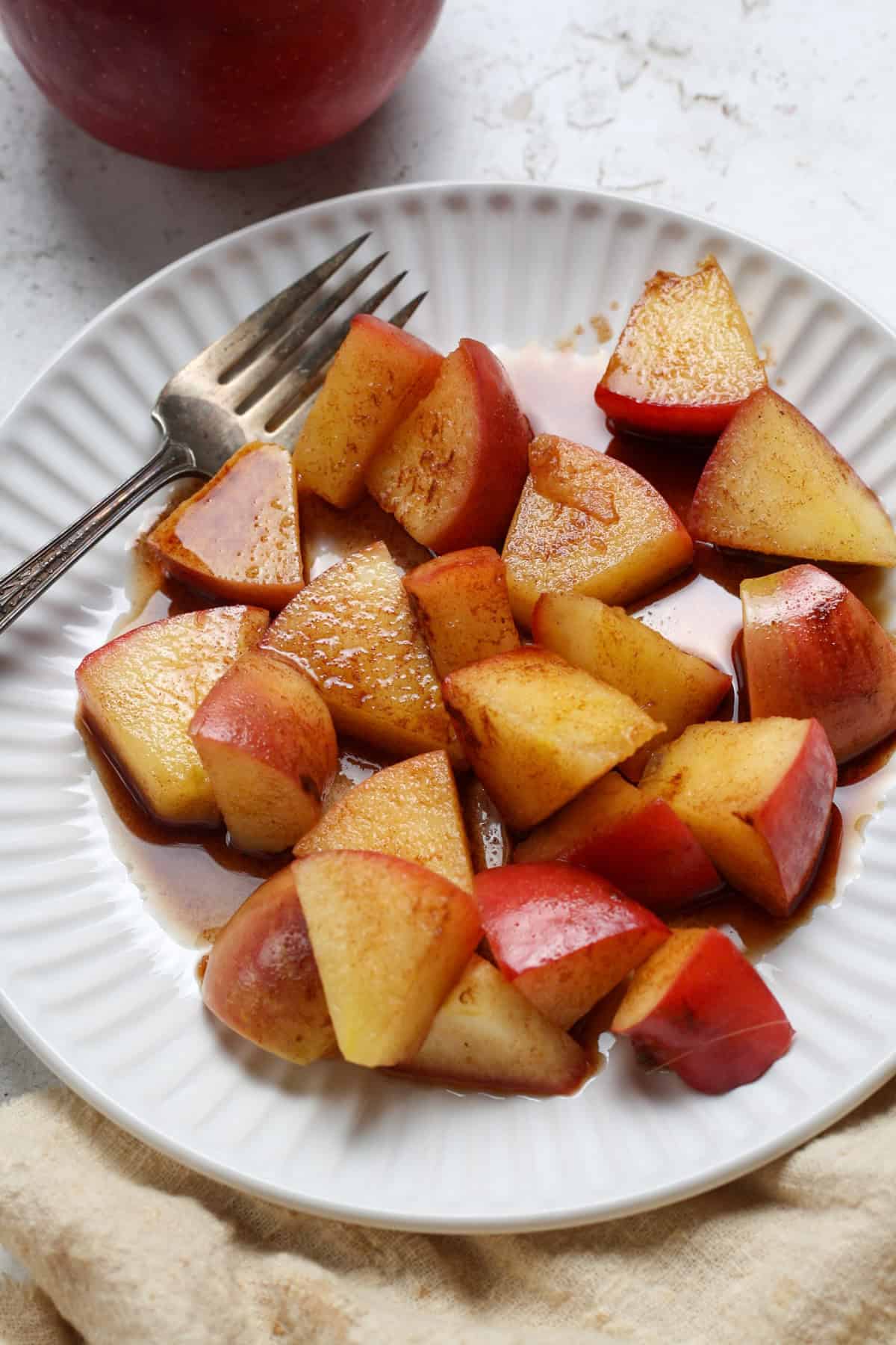 cinnamon apples on a white plate with a fork on the side - main picture 1200x1800