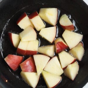 Step 1 of making microwave cinnamon apples - sliced apple cubes in dish with coconut oil