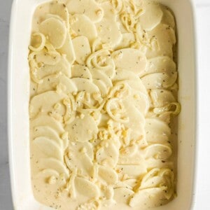 Arranged sliced potatoes in an even layer in the prepared baking dish. Step 4 of process