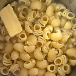 Boiled Pasta with butter on top on a hot pan